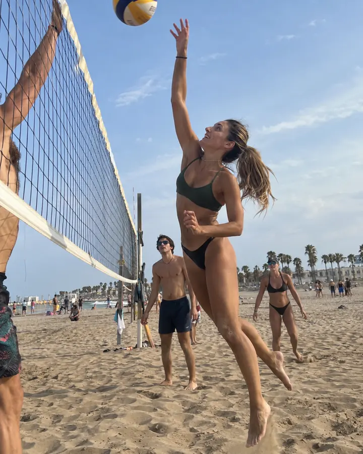 Chica rematando en un partido de vóley playa en Barcelona.